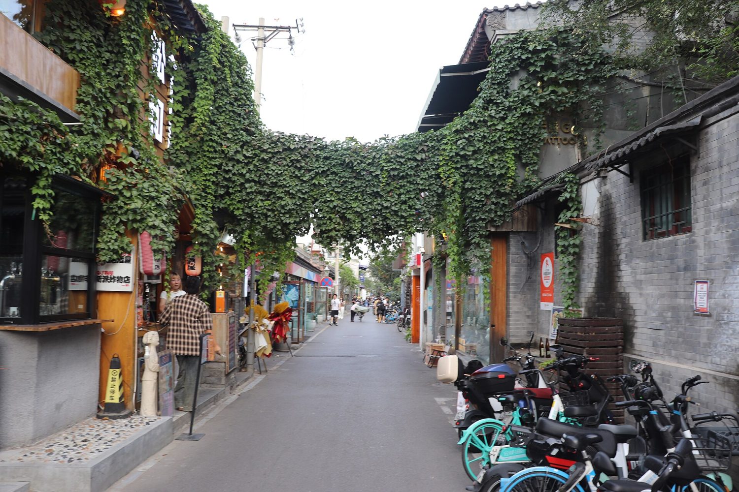 Storefronts and pedestrians along Wudaoying Hutong in Beijing.