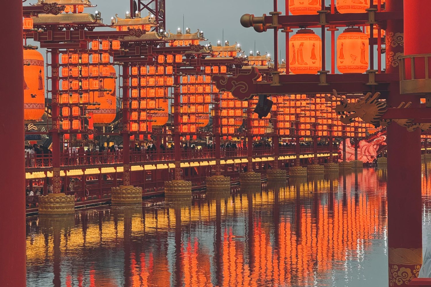 Traditional red lanterns reflect beautifully on water, creating a warm, festive ambiance.