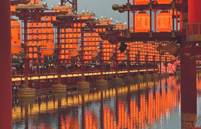 Traditional red lanterns reflect beautifully on water, creating a warm, festive ambiance.