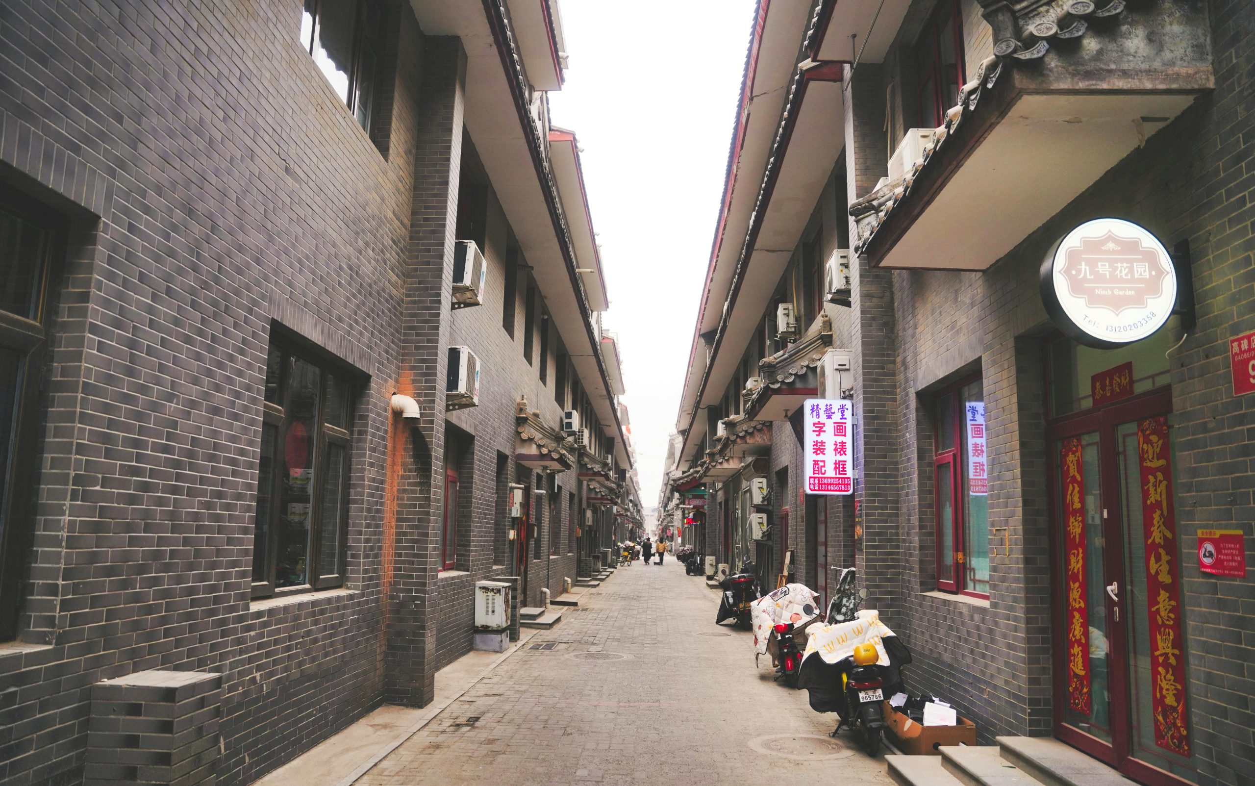 A quiet Beijing alleyway with gray brick architecture and narrow lanes