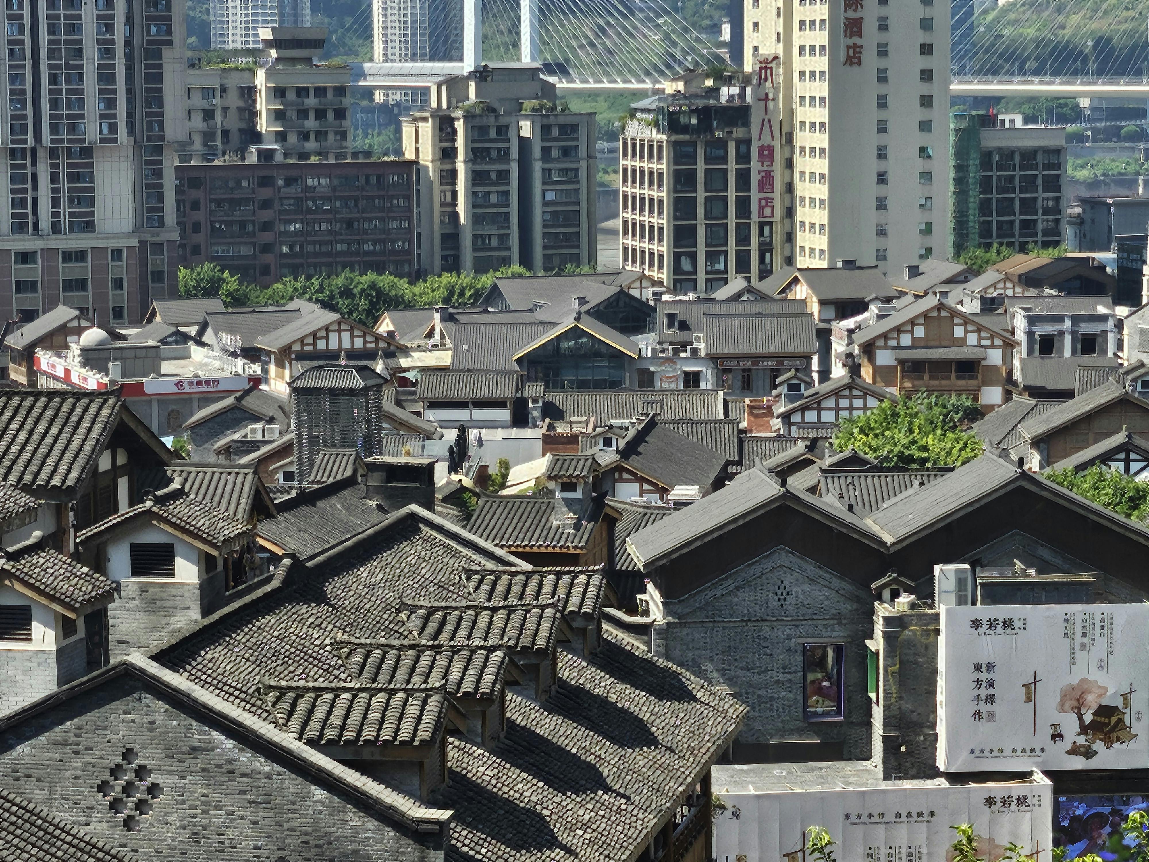 Traditional tiled rooftops in front of modern Chongqing skyscrapers
