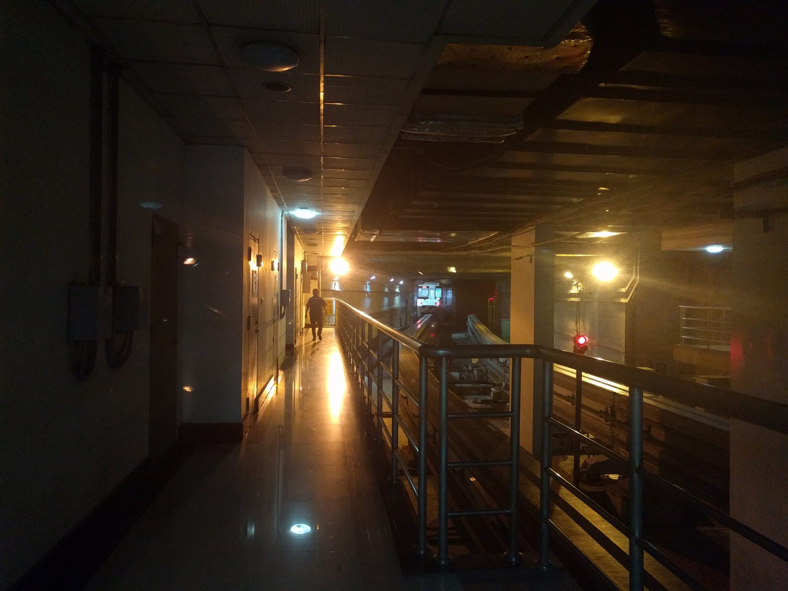Dimly lit corridor inside Liziba station platform alongside the monorail track.