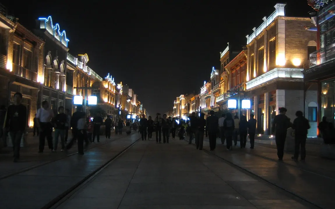 Qianmen Street in Beijing with historic-style storefronts and pedestrians.