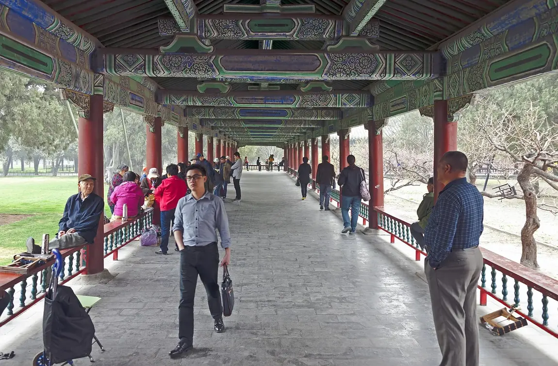 People gathering in the long corridor area of Temple of Heaven Park in Beijing.